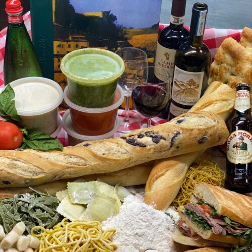 Tables composition: the house menu, baguette breads, focaccia bread, different sauces in containers to-go, bottles of wine, beer, fresh pastas, ravioli, potatoes gnocchi, flour, a prosciutto sandwich and tomato and basil leaves.