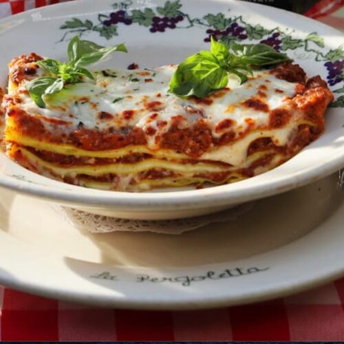 Lasagna Bolognese with basil leaves.